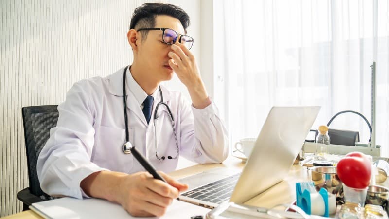 Tired doctor at his computer resident